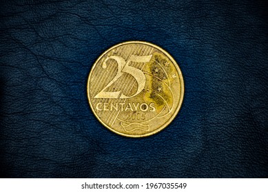 Obverse of used and old Brazilian 25(twenty five) centavos(cents) coin, minted in 2005, on black leather background.