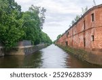 Obvodny Canal in Kronstadt, view of old drainage canal with an abandoned warehouse building on the bank

