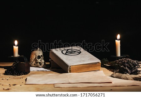 Occult ritual of white magic using grimoire, old book, candles