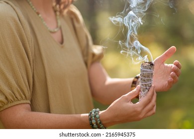 Occult Science And Supernatural Concept - Close Up Of Woman Or Witch With Smoking White Sage Performing Magic Ritual In Forest