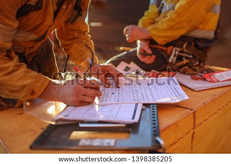 Occupational health and safety miners sign of the work permit on isolation safety control procedure lock box after completed rope access high risk work 12 Hrs shift construction mine site, Australia 
