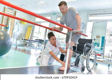 Occupational therapist helping patient to walk