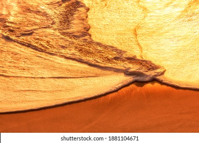 ocean background and texture, foam wave and sand. sea-wave foam on a golden sand by intense sunlight. A timeless feel and showcases the unique beauty in nature. Beautiful golden light golden. shine 