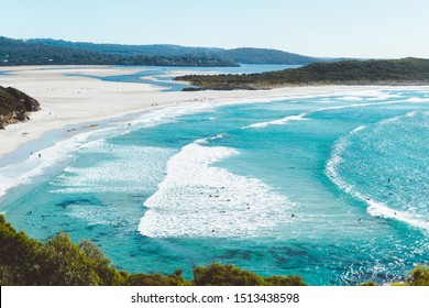 Ocean Beach, Denmark, Australia. Beautiful Wide Beach With Surfers Surfing Waves In Clear Blue Water. River Mouth Can Be Seen In The Background With Some Trees In The Foreground. 