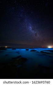 The Ocean Glowing A Brilliant Iridescent Blue And Glittering Sparkly Light From Bioluminescent Algae.  A Magical Phenomenon.  Twinkling Stars Overhead Made A Magical Evening