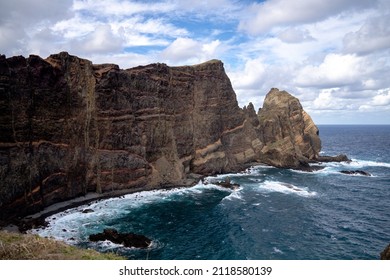 The ocean with high rocky cliffs in Madeira at the Ponta de São Lorenço during a hike on a trail in Madeira with more tourists