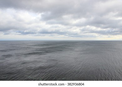 Ocean Horizon With Black Water And Dramatic Clouds Background