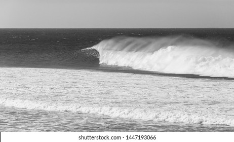 Ocean Overlooking Wave Crashing With Wind Spray In Vintage Black And White Photo.