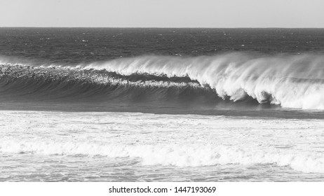 Ocean Overlooking Wave Crashing With Wind Spray In Vintage Black And White Photo.