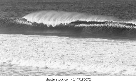 Ocean Overlooking Wave Crashing With Wind Spray In Vintage Black And White Photo.