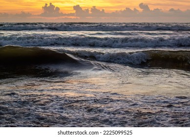 Ocean sea waves coming to shore with white foam bubbles.color reflection of a yellow sky visible on the water surface -  Sri Lanka - Shutterstock ID 2225099525