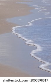 Ocean Seafoam On Sandy Beach At Low Tide