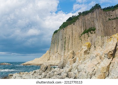 ocean shore with rocks of columnar basalt, Cape Stolbchaty on Kunashir Island - Shutterstock ID 2212770113
