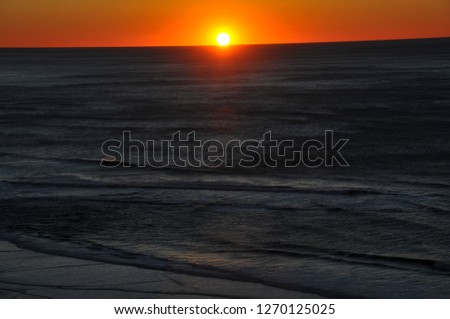 Ocean sunset on the coast of Oregon replicates sand dunes at dusk