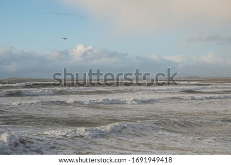 Ocean surface with waves and clouds in the background. Nature landscape, West coast of Ireland. Coast gurad helicopter in the sky. Sligo, Ireland.