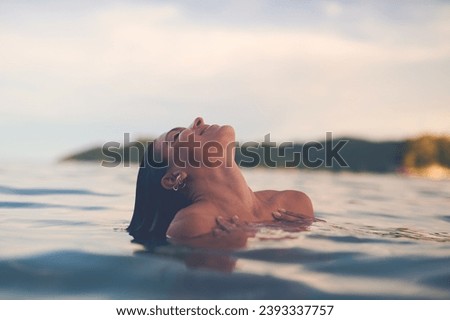 Ocean, swimming and woman with vacation, travel and relax with getaway trip, freedom and outdoor for fun. Person, tourism and girl with holiday, water and summer with weekend break, carefree or smile