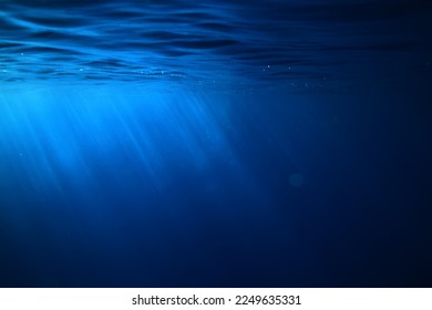 ocean underwater rays of light background, under blue water sunlight