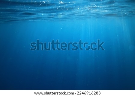 ocean underwater rays of light background, under blue water sunlight