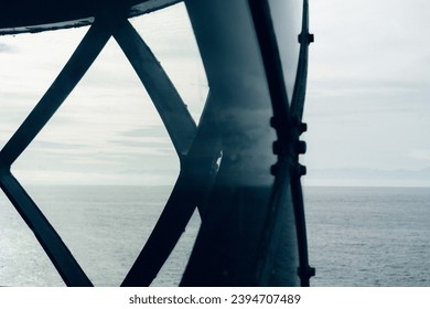 Ocean view through lighthouse window at sunset