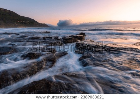 Ocean water flows through rock platforms on the coastline.