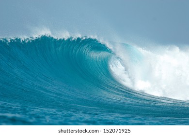 An ocean wave breaks over a shallow reef in the Maldives.
