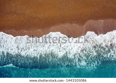 ocean wave on a sandy beach, background  top view of sea