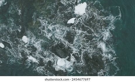 Ocean Wave Snow Rock Aerial Top Down View. Beautiful Coast Cliff in Water Abyss Foam. Power Sea Aqua Surf Winter Antarctica Seascape Nature Drone Flight - Powered by Shutterstock