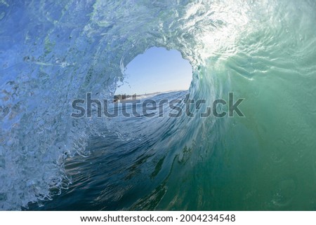 Ocean wave surfing tube ride view inside out perspective of hollow tunnel crashing sea water power.