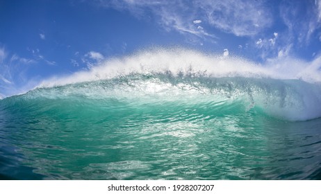 Ocean wave swimming encounter closeup of curling pitching crashing  lip of sea water towards camera with sun backlighting.