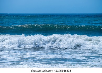 Ocean waves crashing on sandy beach. Sea waves breaking on shore. Nature splash on summer day. Sea wave crashing on beach. Summer holidays concept. Splashing sea water with foam.