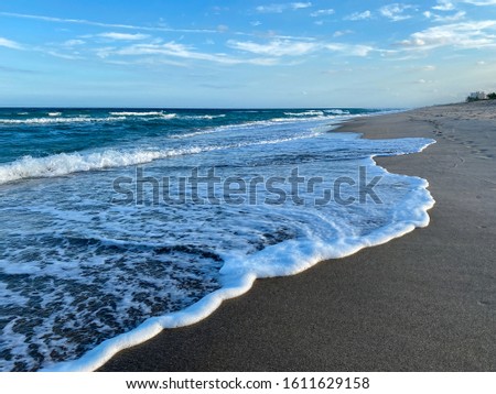 Ocean waves lapping on the beach  on a beautiful sunny day along the shoreline on North Hutchinson Island Florida.