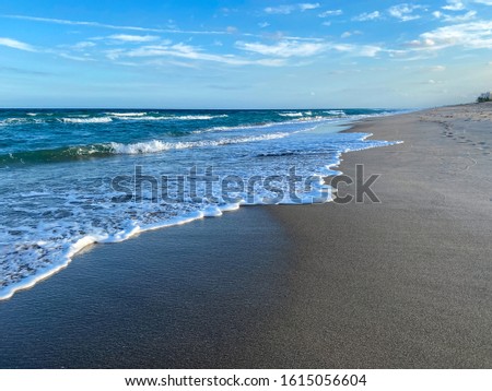 Ocean waves lapping on the beach  on a beautiful sunny day along the shoreline on North Hutchinson Island Florida.