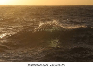 ocean waves lit by the setting sun taken from a ship in the Atlantic ocean