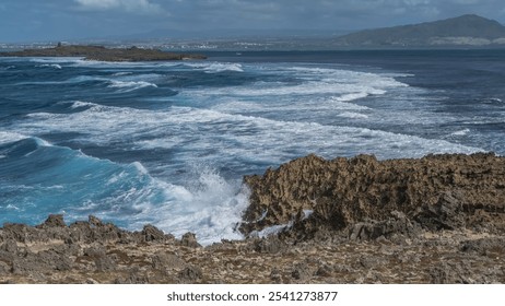 Ocean waves are raging in the strait between rocky volcanic islands. Foam of waves, splashes on the cliffs. The coast of the island of Mauritius is far away. Lighthouse Island  - Powered by Shutterstock