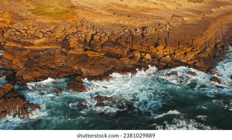 Ocean waves rolling to the rocky shore. Beautiful seascape. Aerial top view of the beautiful ocean rocky shore with rolling waves. Drone is hovering over rolling ocean waves to rocky shore - Powered by Shutterstock