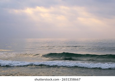ocean waves under clouds sky in the early morning in Sanya, Hainan, China