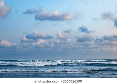 Ocean waves under a cloudy sky at dusk, beach waves atmosphere, cloudy sky view.