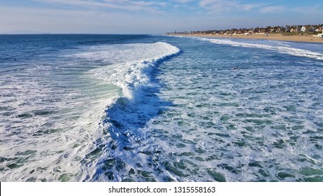 Ocean waves and white wash rolling towards the shore in Huntington Beach California