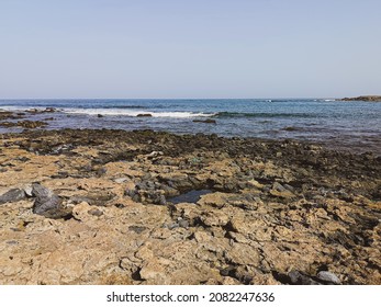 Oceanscape on Boa Vista Island, Cape Verde. Seascape view on a sunny summer day. Waves splashing in to the rocks. Selective focus on the details, blurred background.