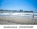 Oceanside City Beach with distant Municipal Pier and ocean waves.