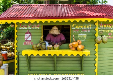 Ocho Rios, Jamaica - April 22, 2019: Ice Cold Coconut Fruit Drink with Rum stall/corner shop in rasta colors at the Ocho Rios Cruise Ship Port in the streets of Ochi, Saint Ann parish.