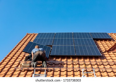Ochojno, Poland - April 8, 2020: Workers installing solar electric panels on a house roof in  Ochojno. Poland - Shutterstock ID 1733738303