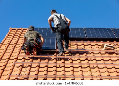 Ochojno, Poland - April 8, 2020: Workers installing solar electric panels on a house roof in  Ochojno. Poland - Shutterstock ID 1747846058