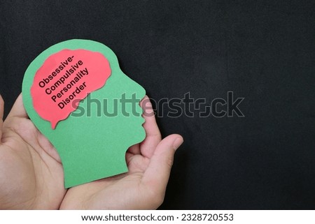OCPD or obsessive compulsive personality disorder help, care and treatment concept. Hand holding human head profile with word text on brain on dark background.