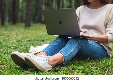 Oct 30th 2020 : A Woman Using And Working On Apple MacBook Pro Laptop Computer In The Park , Chiang Mai Thailand