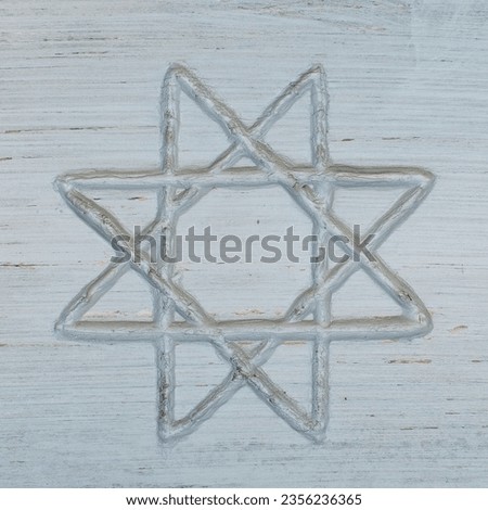 Octagram shape or symbols on white wooden board. Octagram is an eight-angled star polygon used in many different cultures.