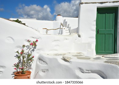 October 1, 2020. Traditional Adobe House With Whitewashed Walls, Stone Steps And A Green Wooden Door In Amorgos Island, Cyclades Greece. 