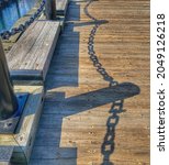 October 10, 2020 - Long Wharf, Boston, MA. Simple photo of the shadow of the dock fence - large chain link and posts.  Contrast against the wood dock.