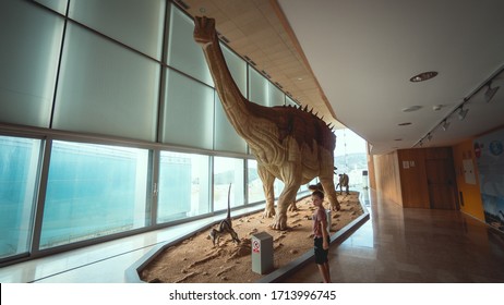 October 12, 2017, Cuenca, Spain: A Replica Of A Patagotitan Mayorum Diplodocus Dinosaur Of Paleontological Museum Of Dinosaurs Of Castilla-La Mancha, Cuenca. Child Boy Looks At Dinosaur.