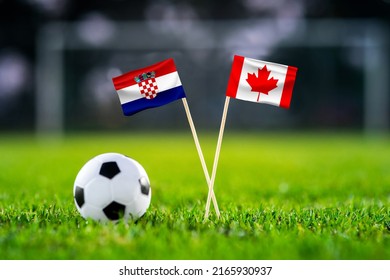 October 2022: Croatia Vs. Canada, Khalifa Stadium, Football Match Wallpaper, Handmade National Flags And Soccer Ball On Green Grass. Football Stadium In Background. Black Edit Space.